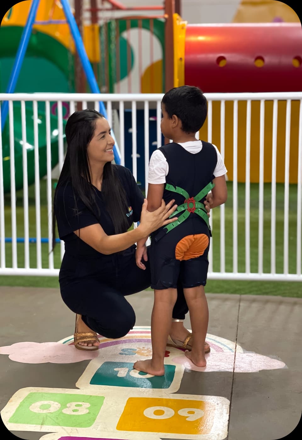 Profissional da Ser Especial acolhendo uma criança em atividade terapêutica